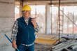 © Ljustina - Senior construction worker using walkie-talkie on building site