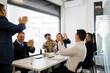 © TrueShot | Westend61 - Happy business colleagues applauding together in meeting at office