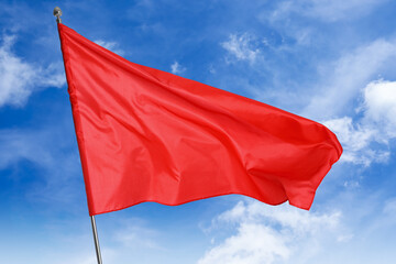 Wall Mural - red flag waving against blue sky outdoors