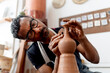 © TrueShot | Westend61 - Close-up of male artist making earthenware while sitting in workshop