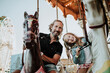 © TrueShot | Westend61 - Father and daughter enjoying carousel ride at amusement park