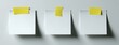 © Fauzi - Three blank white sticky notes with yellow adhesive tabs