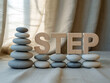 © MdAminul - Stacked zen stones and wooden letters spell out the word step