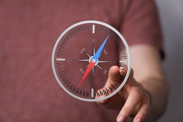 Poster - A person interacts with a digital compass, indicating navigation, direction, or guidance.