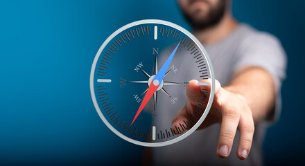 Poster - Stock photo of a man interacting with a digital compass, symbolizing guidance and direction.
