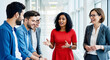 © imfotograf - A female manager of Indian descent leading a productive discussion with her diverse team in an office hallway.