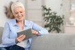 © Prostock-studio - Retirement Leisure. Smiling Elderly Woman Resting With Digital Tablet On Couch At Home, Browsing Internet Or Watching Movies