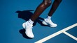 © Dina - White athletic shoes on a blue court.