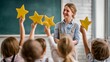 © Darya - Smiling teacher in a classroom as young children raise large yellow stars, symbolizing recognition, achievement, and positive feedback in education.