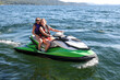© Mat Hayward - Two young women having fun on Couer D'Alene lake in Idaho riding the water on a fast jet ski watercraft outside on a long summer day. The sisters are laughing and enjoying the family time together.