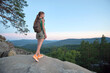 © bilanol - Young woman hiking alone on mountain footpath. Female hiker enjoying view of evening nature on wilderness trail. Active way of life concept