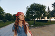 © SHOTPRIME STUDIO - Lifestyle woman in modern boho-western denim street style wearing a red bandana, walking outdoors during golden hour with natural greenery and warm film color tones.