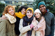 © Xavier Lorenzo - Young happy group of diverse friends in warm clothes smiling at camera standing together outside. Portrait of millennial people enjoying winter vacation. Friendship and youth concept.