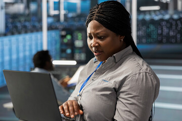 Poster - System administrator in server room using laptop to implement and manage data backup solutions. Data center IT expert identifying and resolving technical errors, ensuring efficient recovery