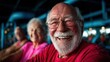© Dulemegapixel - A joyful elderly man with a big smile enjoys his time in a vibrant gym setting, representing community, happiness, and vitality among seniors during physical activity.