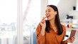 © Home-stock - Young satisfied lady eating piece of black chocolate, holding tile in her hand, enjoying sweet dessert, sitting in kitchen at home