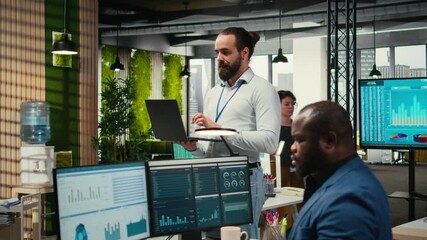 Poster - Male team leader monitoring analytics on a laptop in co working space, handling daily tasks for business productivity. Using performance metrics and other insights for development. Camera A.