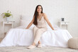 © Pixel-Shot - Morning of beautiful young woman in pajamas sitting on bed