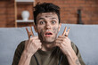 © Pixel-Shot - Electrocuted young man with burnt face and jumper cables at home, closeup