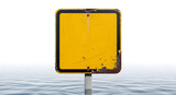 A blank, rusty yellow warning sign submerged in floodwaters, signaling danger or an unknown threat.