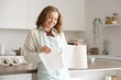 © Pixel-Shot - Young woman with roll of paper towels in kitchen