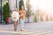 © Pixel-Shot - Senior woman with stick and caregiver crossing road on street