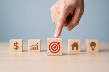 Poster - Target Selection in Planning: A human finger thoughtfully selects a target icon amidst a row of wooden blocks, signifying focused goal setting, planning, and strategic choices.