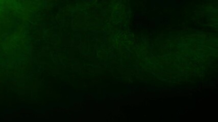 Wall Mural - dark and moody green smoke moves slowly across the screen on a black background. an atmospheric over
