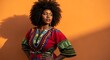 © Muhammad Asyraf - A woman with an afro and colorful dress poses confidently against a vibrant orange backdrop.