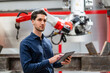 © BusinessClass by W61 - Contemplative engineer holding tablet PC in front of robotic arm