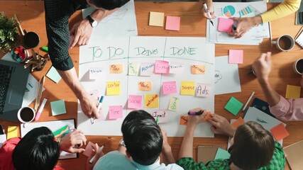 Poster - Top down aerial view of diverse business team making scrum task board at meeting room. Group of smart people writing at paper and sticky notes for making kanban board to manage work flow. Convocation.