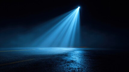 Wall Mural - a strong beam of blue light pierces the darkness, illuminating a wet road covered in mist. the still