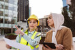 © BusinessClass by W61 - Engineer wearing hardhat discussing with businesswoman holding tablet PC