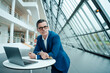 © BusinessClass by W61 - Thoughtful businessman with credit card leaning by laptop on table at office