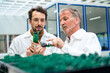 © BusinessClass by W61 - Senior engineer discussing over circuit board with colleague at industry