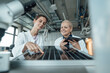 © BusinessClass by W61 - smiling scientists discussing over solar panel in laboratory