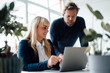 © BusinessClass by W61 - Happy businesswoman having discussion with colleague over laptop in office