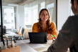 © BusinessClass by W61 - Smiling architect sitting with tablet PC and discussing with colleague at desk