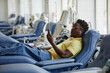 © BusinessClass by W61 - Man donating blood and using smart phone