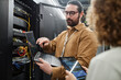 © BusinessClass by W61 - IT professionals discussing over data on laptop and tablet PC in server room