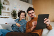 © BusinessClass by W61 - Illustrator explaining colleague over graphic tablet sitting on sofa at office