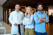 © BusinessClass by W61 - Happy multiracial colleagues with arms crossed standing in library
