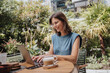 © BusinessClass by W61 - Smiling working woman using laptop in yard