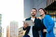© BusinessClass by W61 - Businessman explaining to colleague standing with hand on hip