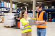 © BusinessClass by W61 - Happy worker discussing over tablet PC with young colleague in warehouse