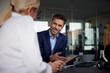 © BusinessClass by W61 - Smiling businessman discussing over tablet PC with colleague in office
