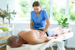 © JackF - Skilled middle-aged masseuse conducting back massage therapy for man client in procedure room