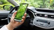 © PaulShlykov - Woman holding smartphone inside car with green trees reflected on screen