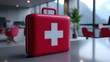 © PengAI - A red first aid kit with a white cross sits on a table in a modern office setting with blurred chairs and plants in the background.