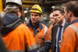 © pisan thailand - A group of workers and a businessman in a factory discuss work, with safety gear and serious expressions.